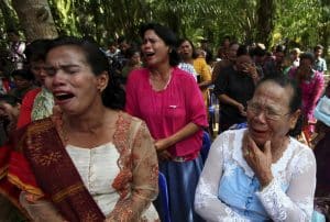 Residents cry as they attend a Sunday mass prayer near a burned church at Suka Makmur Village in Aceh Singki