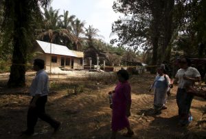 Residents walk near a burned church to attend Sunday mass at Suka Makmur Village in Aceh Singkil